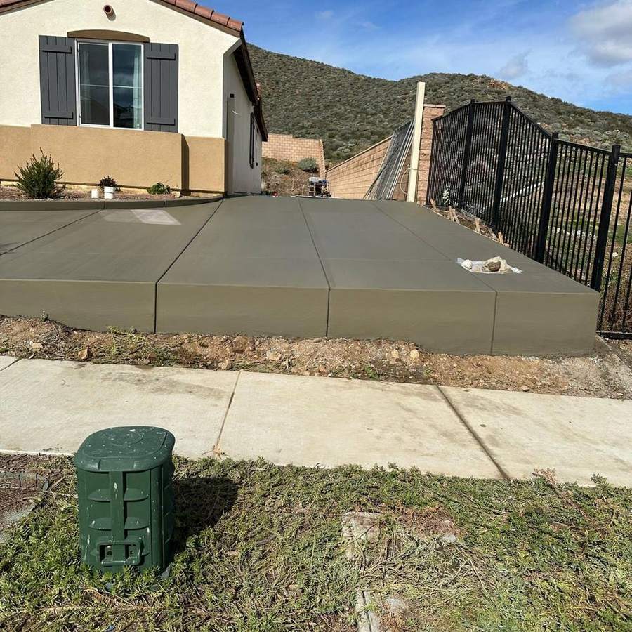 Raised concrete pad beside a driveway gate